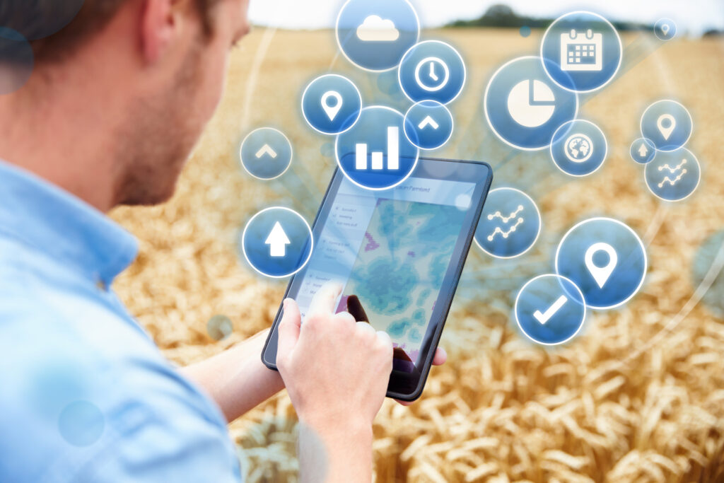 Farmer In Field Accessing Data On Digital Tablet